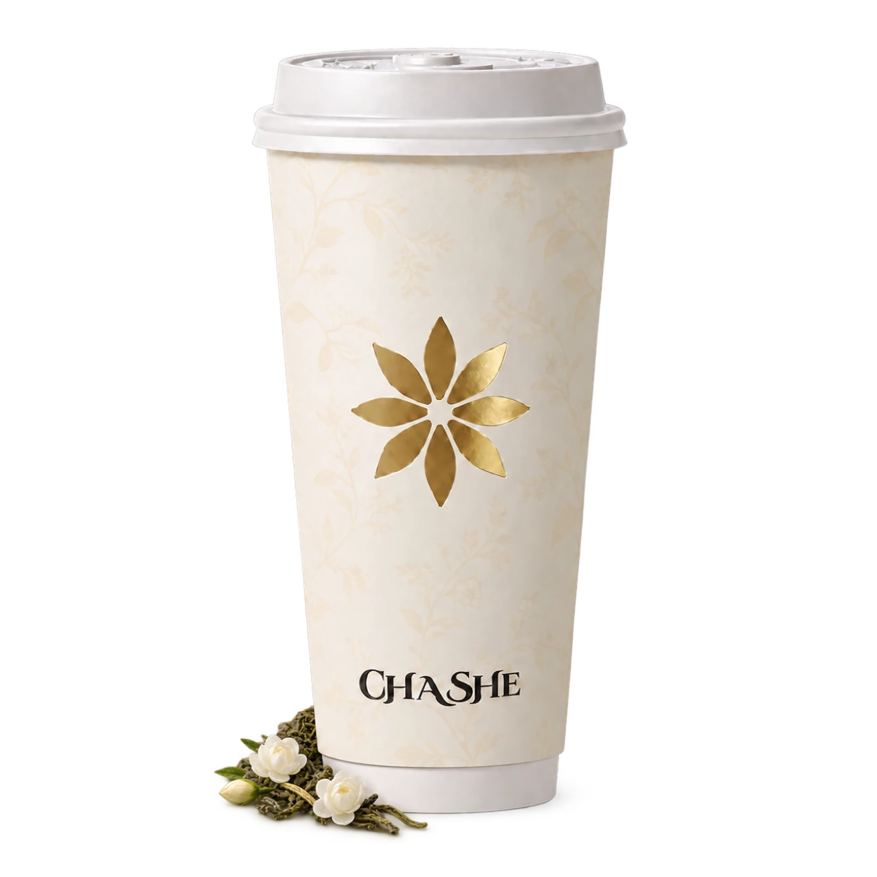 Ivory CHASHE paper cup with a white petal lid and small white jasmine blossoms beside loose green tea leaves resting around its base